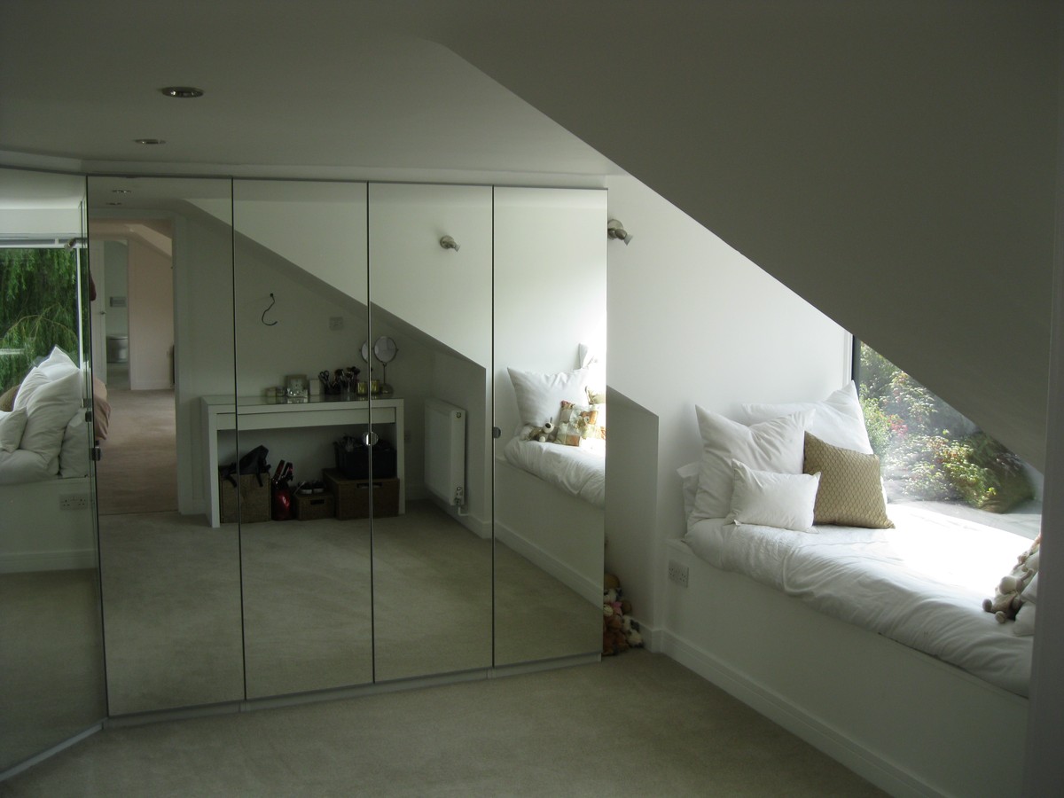 Loft conversion with bespoke mirrored wardrobes and window seat by RMJ Carpentry