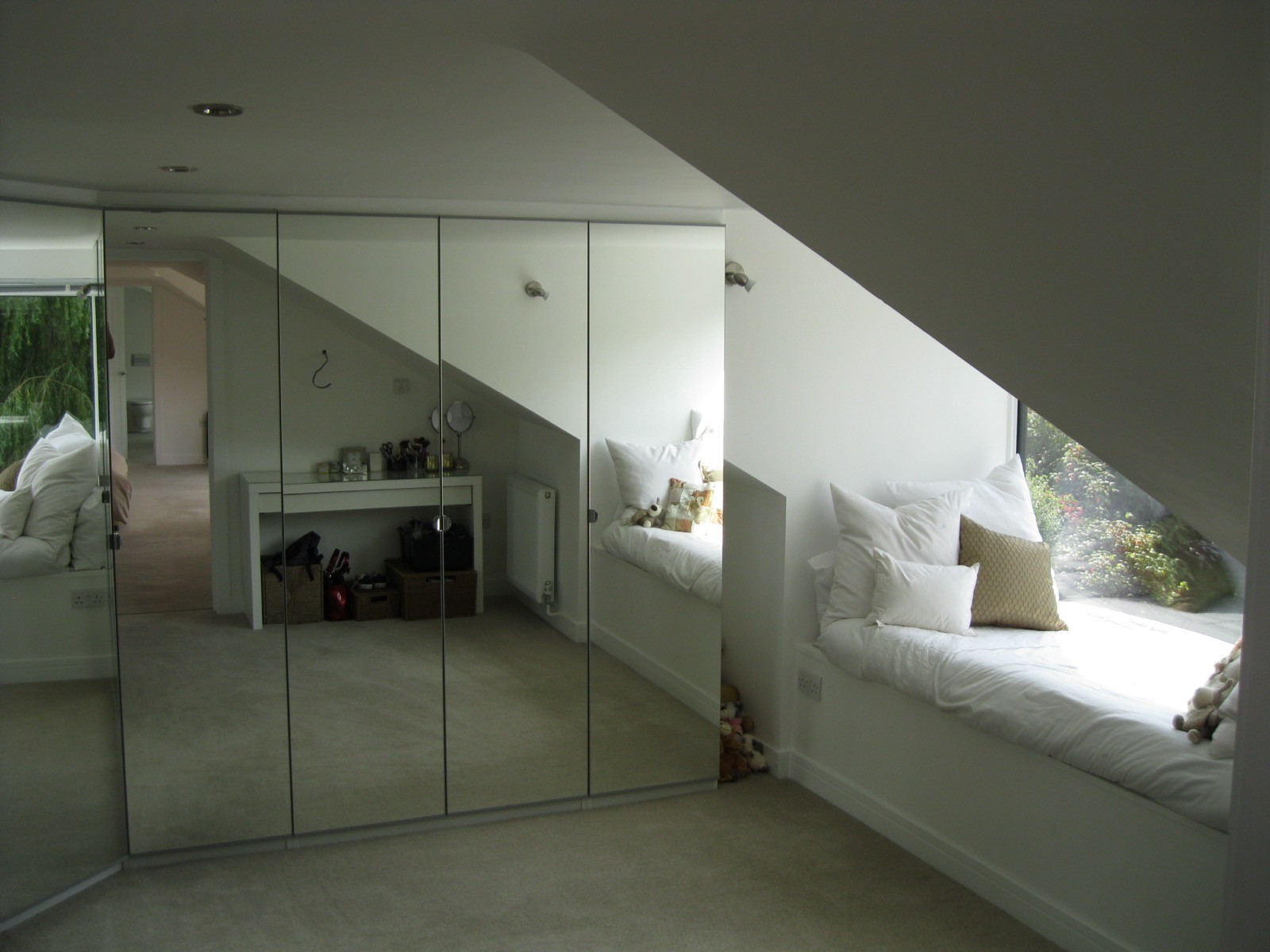 Loft conversion with mirrored wardrobes and window seat